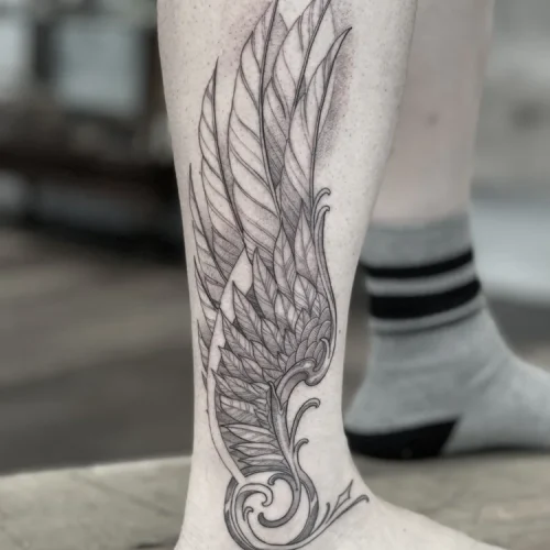 Fine-line black and grey tattoo of a wing on leg | Downtown Las Vegas